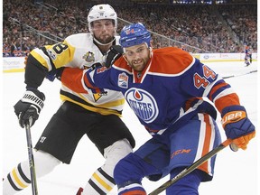 Pittsburgh Penguins' Brian Dumoulin and Edmonton Oilers' Zack Kassian vie for a puck along the boards in Edmonton on Friday, March 10, 2017. (The Canadian Press)