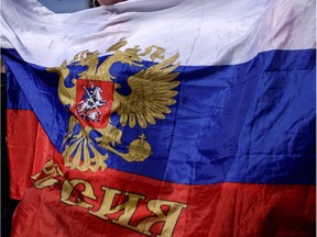 A woman shouts slogans as she holds a Russian flag during a political rally on Bulgaria's National Day in central Sofia on March 3, 2017.  Member of NATO since 2004 and of the European Union since 2007, Bulgaria, which elects its Parliament on March 26, has historical, cultural and economic ties with Russia that are unmatched within the EU. /