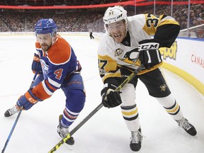 Pittsburgh Penguins' Carter Rowney (37) and Edmonton Oilers' Kris Russell (4) vie for the puck during first period NHL action in Edmonton, Alta., on Friday, March 10, 2017.