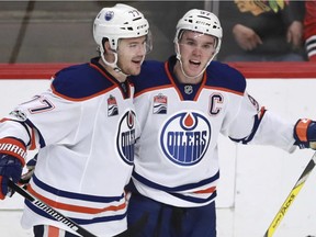 Edmonton Oilers center Connor McDavid (97) celebrates his empty net goal against the Chicago Blackhawks with teammate Oscar Klefbom (77) during the third period of an NHL hockey game Saturday, Feb. 18, 2017, in Chicago.
