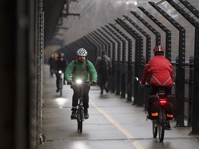 Cyclists and walkers mingle as they commute over the High Level Bridge along the safety barrier in Edmonton, Alberta on Friday, October 28, 2016.