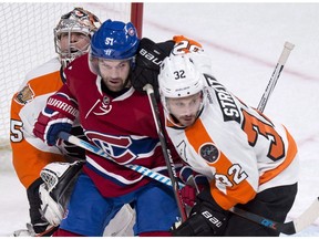 Montreal Canadiens' David Desharnais (51) gets caught in between Philadelphia Flyers goalie Steve Mason and defenceman Mark Streit (32) during first period NHL hockey action, in Montreal on Monday, October 24, 2016.