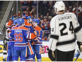 A group of Edmonton Oilers celebrate a goal as Los Angeles Kings' Derek Forbort skates by in Edmonton on Dec. 29, 2016. (The Canadian Press)