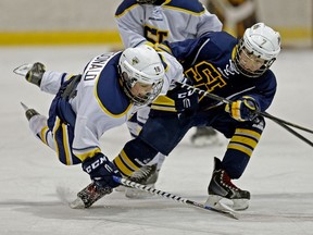 St. Albert Blades Brennan MacDonald (#15) is checked by St. Albert Titans Kaiden Jean (#7) during a Minor Hockey Week peewee playoff game at the Terwillegar Community Recreation Centre in Edmonton on January 17, 2016. The Titans defeated the Blades by a score of 2-1.