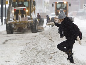 A pedestrian makes her way over a windrow left behind as graders cleared snow along 102 Avenue near 101 Street.