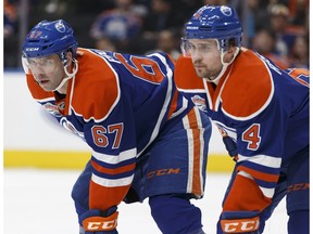 Edmonton's Benoit Pouliot (67) and Kris Russell (4) faceoff during the first period of a NHL game at Rogers Place in Edmonton on Friday, January 20, 2017.