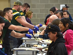 Eskimos players (front to back) Nate Coehoorn, David Beard and Justin Sorensen volunteered to serve roast beef at an annual dinner on Sunday, March 19 ,2017. The dinner serves approximately 1,200 inner-city residents each year at the Boyle Street Plaza.