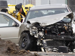 Edmonton Police Service members investigate a fatal two-vehicle crash involving an unmarked police vehicle on 75 Street at 76 Avenue in Edmonton on Thursday March, 8  2012. An 84-year-old woman died and the police officer received serious but non-life threatening injuries.
