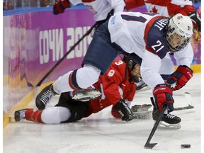 In this Feb. 20, 2014, file photo, the United States' Hilary Knight passes the puck against Team Canada during the women's gold medal game at the Sochi Winter Olympics in Russia. After players threatened Wednesday, March 15, 2017, to boycott the upcoming world hockey championships over a wage dispute, USA Hockey said it will "field a competitive team" for the International Ice Hockey Federation Women's World Hockey Championship beginning March 31 in in Plymouth, Mich. "We're unanimously united as a player pool," Knight said. "Good luck getting a suitable No. 1 competition to represent our country on a world stage. I kind of dare them. It's tough." (The Canadian Press)