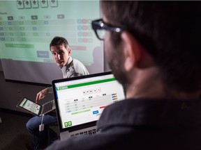 Researchers Michael Bowling, seated, and Michael Johanson are seen in a lab. For the first time researchers in the Computer Poker Research Group at the Faculty of Science, University of Alberta have essentially solved heads-up limit hold 'em poker.