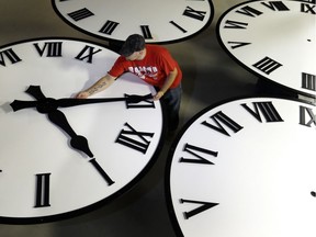 Dan LaMoore sizes hands for an 8-foot diameter silhouette clock at Electric Time Co., in Medfield, Mass. File photo.