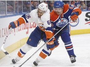 New York Islanders' Josh Ho-Sang (66) and Edmonton Oilers' Adam Larsson (6) battle for the puck during first period NHL action in Edmonton, Alta., on Tuesday, March 7, 2017.