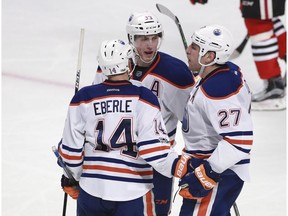Edmonton Oilers left wing Milan Lucic (27) celebrates his goal against the Chicago Blackhawks with teammates Jordan Eberle (14) and Ryan Nugent-Hopkins (93) during the third period of an NHL hockey game Saturday, Feb. 18, 2017, in Chicago.
