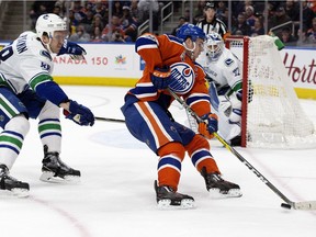 The Edmonton Oilers' captain Connor McDavid (97) battles the Vancouver Canucks defenseman Nikita Tryamkin (88) during second period NHL action at Rogers Place, in Edmonton Saturday, March 18, 2017.