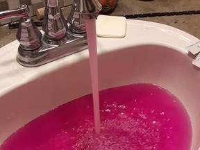 Pink-coloured water flows from a faucet in a handout photo. Residents in a small town northwest of Edmonton say bright pink water coming out of their taps was a bit of a shock.