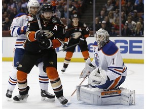 Anaheim Ducks centre Ryan Kesler keeps his eyes on the mid-air puck that rebounded off Edmonton Oilers goalie Laurent Brossoit with defenceman Andrej Sekera, left, odefending during the second period of an NHL hockey game in Anaheim, Calif., on March 22, 2017.