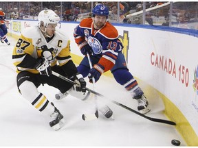 Pittsburgh Penguins' Sidney Crosby (87) and Edmonton Oilers' David Desharnais (13) battle for the puck during second period NHL action in Edmonton, Alta., on Friday, March 10, 2017.