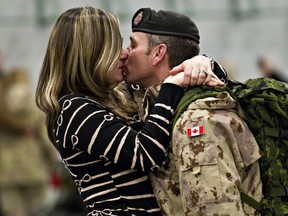Master Warrant Officer Don Cormier, right, is greeted enthusiastically by his wife, Jennifer Cormier, at the Lecture Training Facility at CFB Edmonton in Edmonton, Alta., on Friday, Dec. 13, 2013. Approximately 35 members of the Canadian Armed Forces returned to Edmonton from Afghanistan.