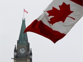 The Canadian flag is seen with the Peace Tower on Parliament Hill in Ottawa.