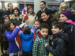 People are on hand to greet refugees from Syria at the Edmonton International Airport on Monday, Dec. 28, 2015.