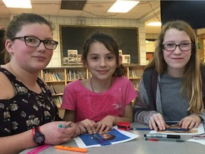 Eleanor Hall School students Brieanna Nyal (left), Haley Ford (centre), and Madison Shank (right) analyze the shape of their face as part of the school's Women Studies class at Eleanor Hall school in Clyde, Alberta.