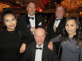 Secret agent Frank Flaman (seated centre) at his James Bond party Friday night at the Fantasyland Hotel with his bodyguards (back left) Flaman GM Rocky Amson and Edmonton Eskimo President and CEO Len Rhodes. The "Bond girls" (l to r) are Apole Tovillo and Kyra Hidalgo,, both studying nutrition at the U of A and Diabetes Foundation volunteers.