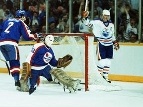 Edmonton Oilers captain Wayne Gretzky celebrates behind the net as Winnipeg Jets goalie Mike Veisor and defenceman Moe Mantha look on on April 4, 1984, during Game 1 of their Smythe Division semifinal playoff series at Edmonton's Northlands Coliseum. Gretzky uncharacteristically went pointless in the 9-2 Oilers win.