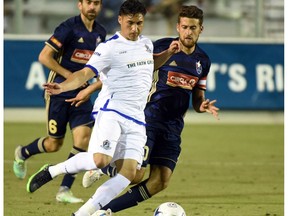 FC Edmonton midfielder Dustin Corea plays the ball in front of  North Carolina FC midfielder Nazmi Albadawi in North American Soccer League play on Saturday, April 15 at WakeMed Soccer Park in Cary, North Carolina. North Carolina FC won 3-1.
