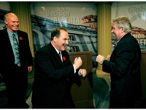 File - Then NDP leader Brian Mason (centre) and premier Ralph Klein pretend to duke it out while Liberal leader Kevin Taft watches after the Alberta leaders debate during the 2004 election.