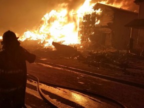 A firefighter battles fires engulfing a burning home in Stone Creek part of Timberlea a photo taken by Fort McMurray firefighter Capt. Matt Collins during the Fort McMurray wildfires that hit the city on May 3, 2016. Photo by Matt Collins
