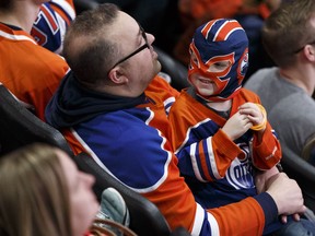 A young boy and his father watch the Edmonton Oilers play the San Jose Sharks during the Oilers Orange Crush Road Game Watch Party at Rogers Place in Edmonton on Sunday, April 16, 2017.
