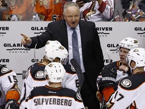 Anaheim Ducks head coach Randy Carlyle, top, gives instructions to his players, including right wing Ondrej Kase (86), center Ryan Kesler (17), defenseman Hampus Lindholm (47) and right wing Jakob Silfverberg (33) during the third period of an NHL hockey game against the Arizona Coyotes Saturday, Jan. 14, 2017, in Glendale, Ariz.  The Ducks defeated the Coyotes 3-0.