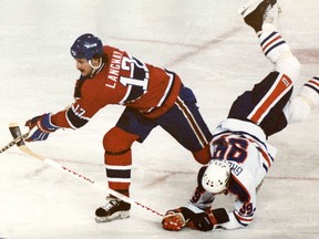Wayne Gretzky takes a spill going for the puck against Rod Langway of the Montreal Canadiens in January 1981.