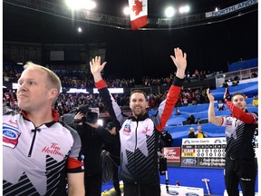 Canada third Mark Nichols, left, skip Brad Gushue and second Brett Gallant celebrate after defeating Sweden in the gold medal game at the Men's World Curling Championships in Edmonton, Sunday, April 9, 2017. (Jonathan Hayward/The Canadian Press)