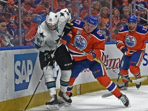 Connor McDavid (97) of the Edmonton Oilers hits Justin Braun of the San Jose Sharks at Rogers Place in Edmonton on April 14,  2017.