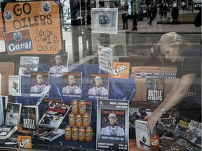 Deborah Hines of Audrey's Books on Jasper Avenue adjusts some of the items in an Oilers window display with books and Orange soda pop  on April 26,  2017.