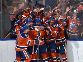 Edmonton Oilers players celebrate teammate David Desharnais's overtime goal to defeat the San Jose Sharks 4-3in Game 5 of their first-round NHL playoff series on April 20, 2017, at Rogers Place.