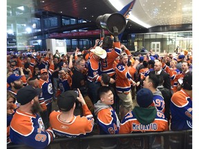 Fans celebrate while surround the statue of Wayne Gretzky outside Rogers Place stadium after the Edmonton Oilers defeated the San Jose Sharks in overtime on April 21, 2017. (Ed Kaiser)