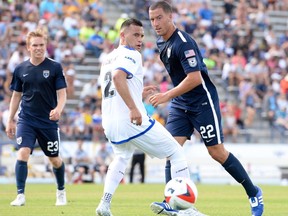 Jacksonville Armada FC defender Kalen Ryden, right, plays the ball past FC Edmonton defender Shawn Nicklaw, while Armada midfielder Zack Steinberger looks on during North American Soccer League play in Jacksonville, Fla., on April 2, 2017. (Supplied/Jacksonville Armada FC)