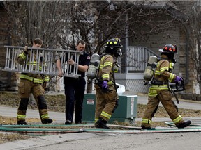 Firefighters leave the scene of a house explosion and fire at 12142-16 Avenue SW in Edmonton on Friday April 7, 2017. Police are investigating the fire.