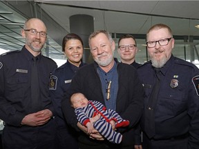 Frank Rieckmann (middle), holding his grandson Kade Temke, with his life savers, Canadian Border Services Agency (CBSA) employees (left to right) Tim Boulton, Tina Buffalo, Dan Rawlyk and Darren Dahlseide at the Edmonton International Airport on April 18, 2017.