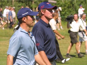 Wayne Gretzky, right, and Mike Weir walk the Northern Bear golf course during the Gretzky and Friends golf tournament on July 23, 2002. (File)