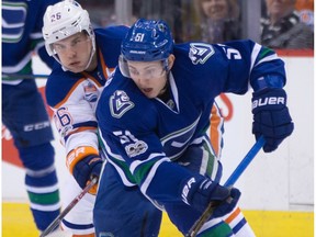 Vancouver Canucks' Troy Stecher, right, moves the puck while being checked by Edmonton Oilers' Iiro Pakarinen during first period NHL hockey action in Vancouver, B.C., on Saturday, April 8, 2017.