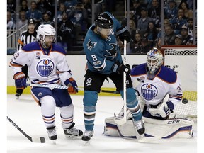 Edmonton Oilers goalie Cam Talbot (33) stops a shot from San Jose Sharks center Joe Pavelski (8) next to Oilers center David Desharnais (13) during the first period in Game 3 of a first-round NHL hockey playoff series, Sunday, April 16, 2017, in San Jose, Calif.