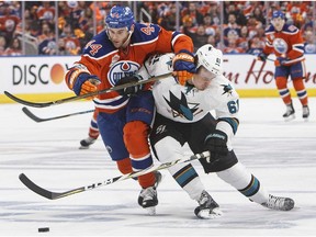 San Jose Sharks' Justin Braun (61) and Edmonton Oilers' Zack Kassian (44) battle for the puck during second period NHL playoff action in Edmonton, Alta., on Friday April 14, 2017.
