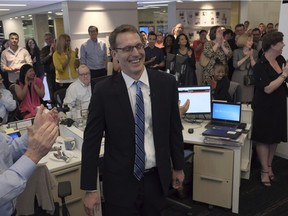 Members of the Washington Post staff congratulate David Fahrenthold, center, upon learning that he won the Pulitzer Prize for National Reporting, for dogged reporting of Donald Trump's philanthropy, in the newsroom of the Washington Post in Washington on Monday, April 10, 2017. (Bonnie Jo Mount/The Washington Post via AP) ORG XMIT: DCWAP102