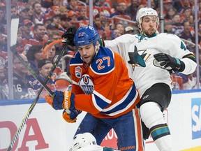 Milan Lucic (27)of the Edmonton Oilers hits Brenden Dillon of the San Jose Sharks in Game Two of the NHL first round playoffs at Rogers Place in Edmonton on April 14,  2017.