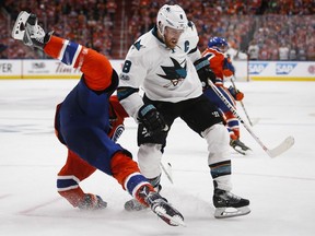 San Jose Sharks' Joe Pavelski, right, upends Edmonton Oilers' Milan Lucic during third period NHL hockey round one playoff action in Edmonton, Thursday, April 20, 2017.