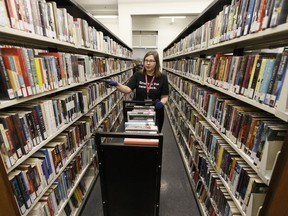 Page Karen Wingerak returns books to the shelves inside the Edmonton Public Library's newly opened Entreprise Square Branch at 10212 Jasper Avenue in Edmonton, Alberta on Tuesday, January 3, 2017.