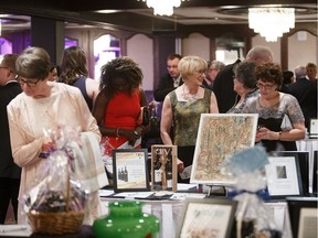 People check out the silent auction during the Pilgrims Hospice's 22nd annual Walk in my Shoes at the Chateau Lacombe in Edmonton on Friday, April 7, 2017.